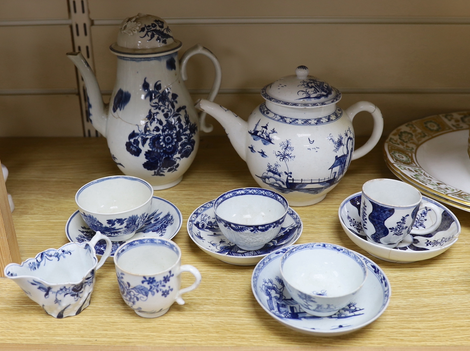 A collection of 18th century Worcester and Lowestoft blue and white tea and coffee wares, including a Lowestoft long fence pattern teapot and cover and a similar tea bowl and saucer